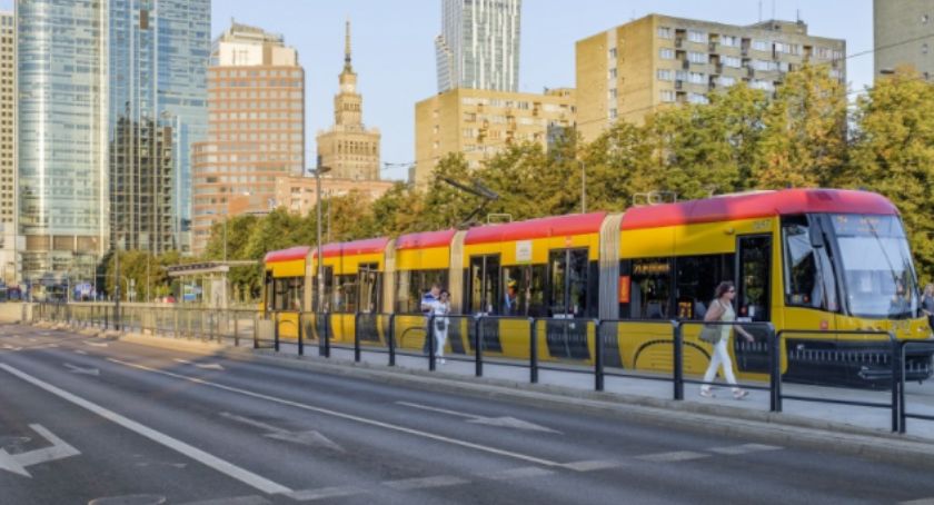 Tramwaj w Warszawie, spacerujący ludzie, w tle Pałac Kultury i Nauki.