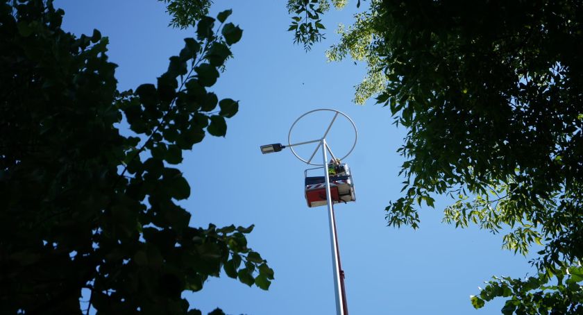 Pracownicy ZDM na wysokości montują nowe lampy. 