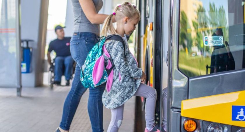Dziewczynka z tornistrem wchodząca do autobusu